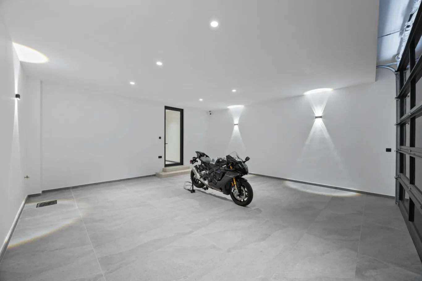 Garage interior with grey flooring and a sports motorbike, luxury villa in Jumeirah Islands, Dubai.