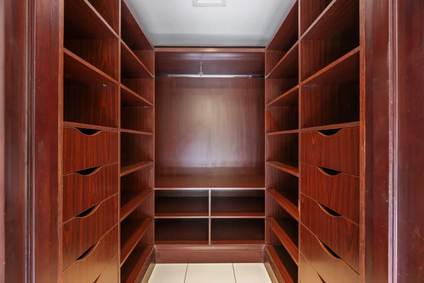 Walk-in wardrobe with dark wood shelving in an unfurnished two-bedroom garden apartment in Old Town, Downtown Dubai, photographed for ELITE Property Brokerage.