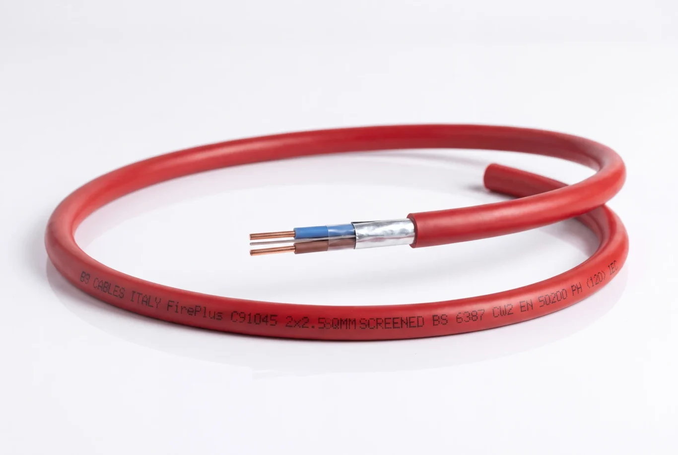 Studio product photo of a coiled red fire resistant cable with its copper cores and foil screen visible.