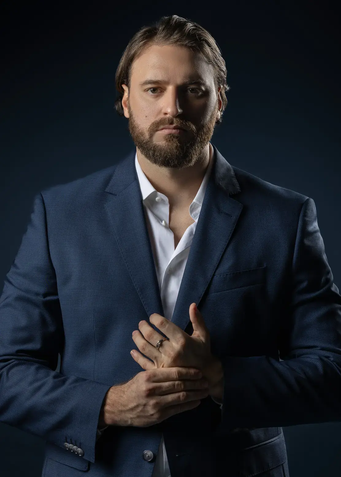 Executive business portrait in a navy suit on a dark blue backdrop. Business portrait from an AI digital twin photoshoot at the MRPS studio in Dubai.