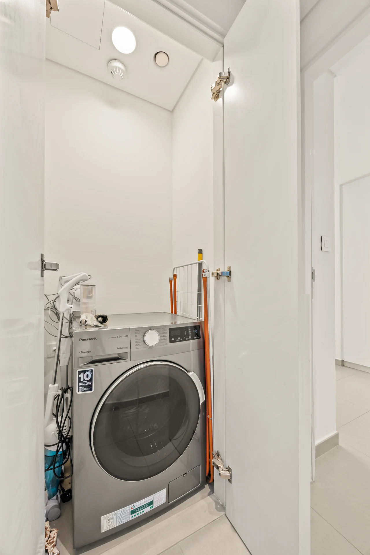 Laundry cupboard with washing machine in the apartment. Day, twilight and night Airbnb photography by MRPS for Vista Haus Holiday Homes in Downtown Dubai.