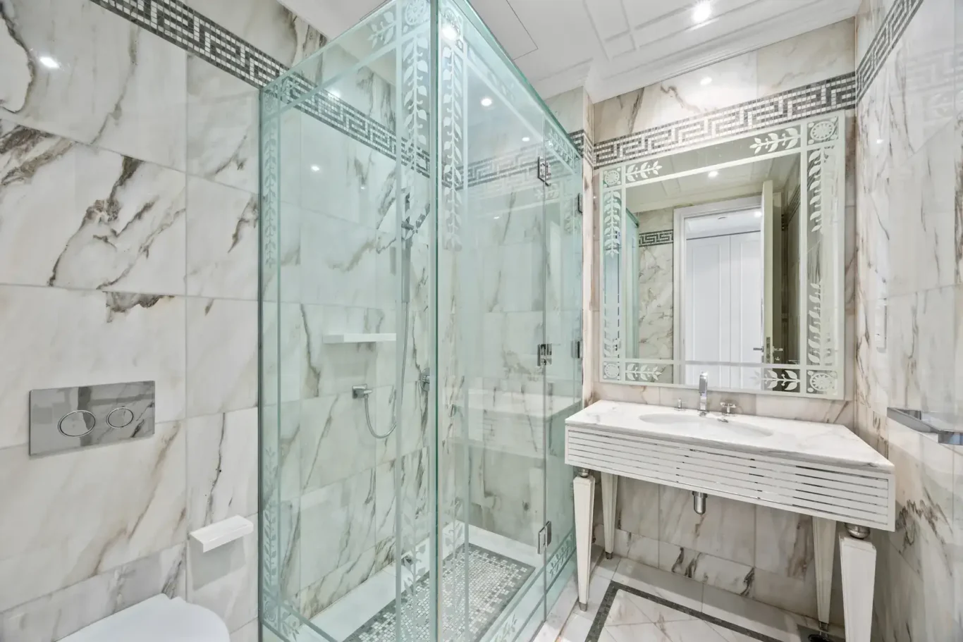 Marble shower and vanity with Greek key border in a three-bedroom residence at Palazzo Versace Dubai, Jaddaf Waterfront, photographed for Concierge Auctions.