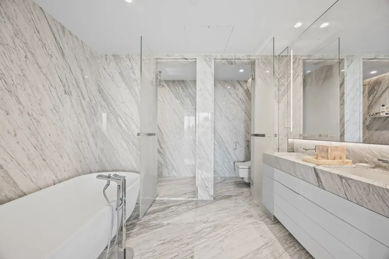 Master bathroom with freestanding bathtub and marble walls in a furnished three-bedroom residence at Atlantis The Royal, Palm Jumeirah, photographed for Apex Homes Real Estate.