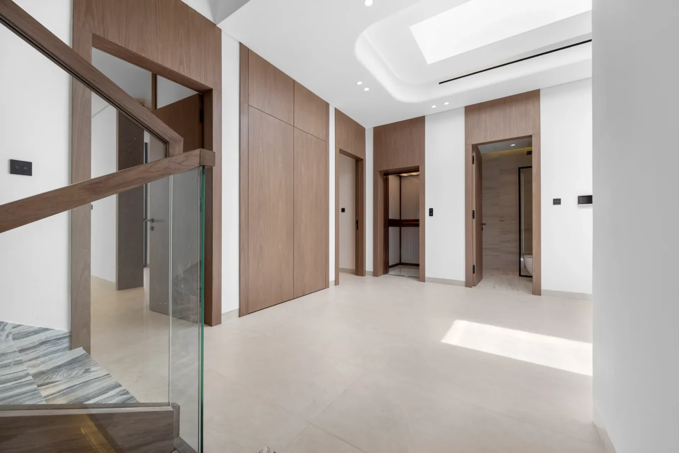 First floor landing with walnut doors and a skylight, unfurnished five-bedroom villa in Al Furjan, Dubai.