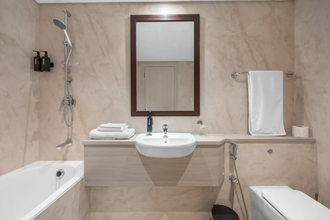 Bathroom with bathtub, vanity and shower in a Your Stay Apartments one-bedroom at Sky Gardens, DIFC, Dubai.