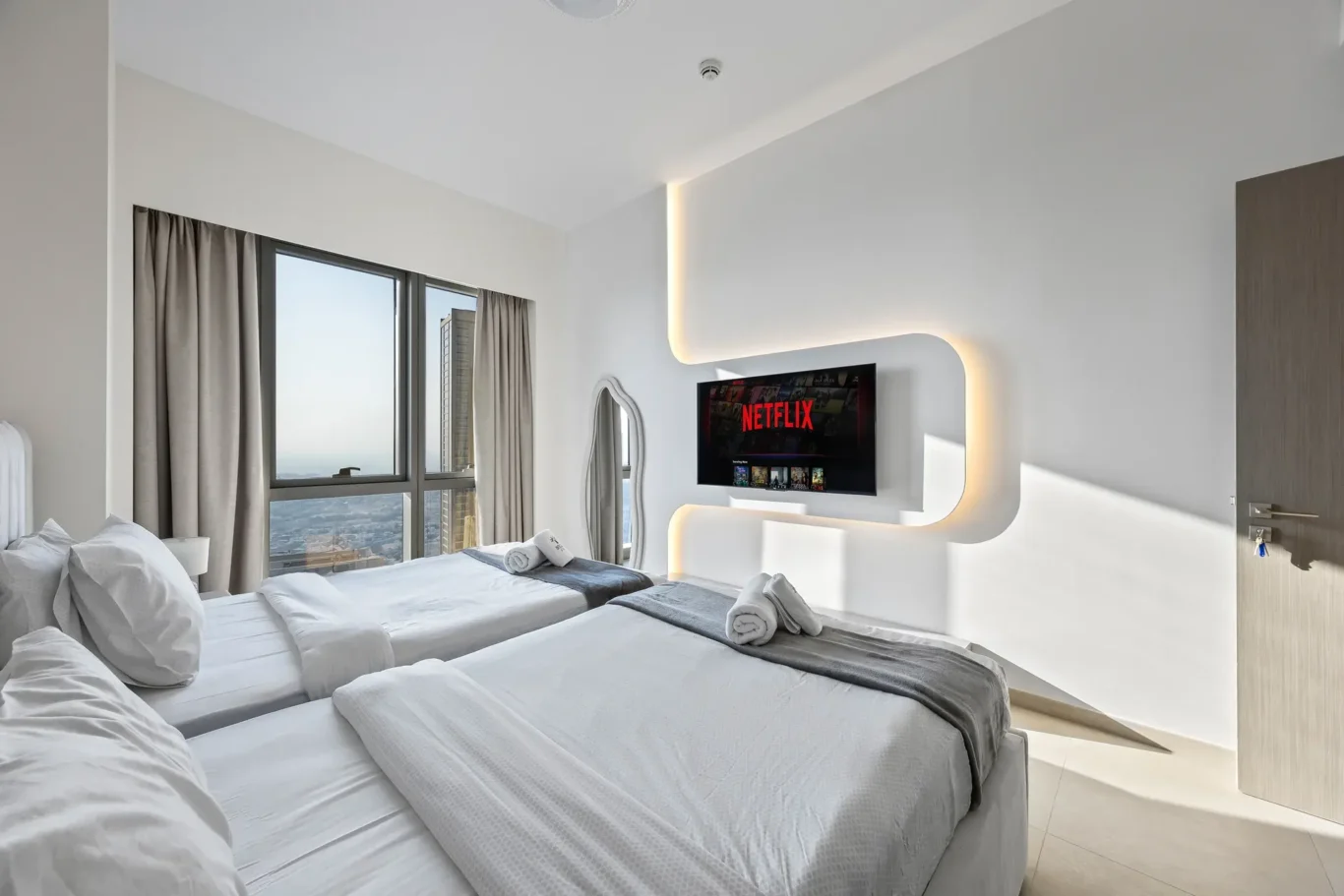 Second bedroom with LED framed TV wall and skyline windows. Airbnb photography by MRPS for Solea Stay in Dubai.