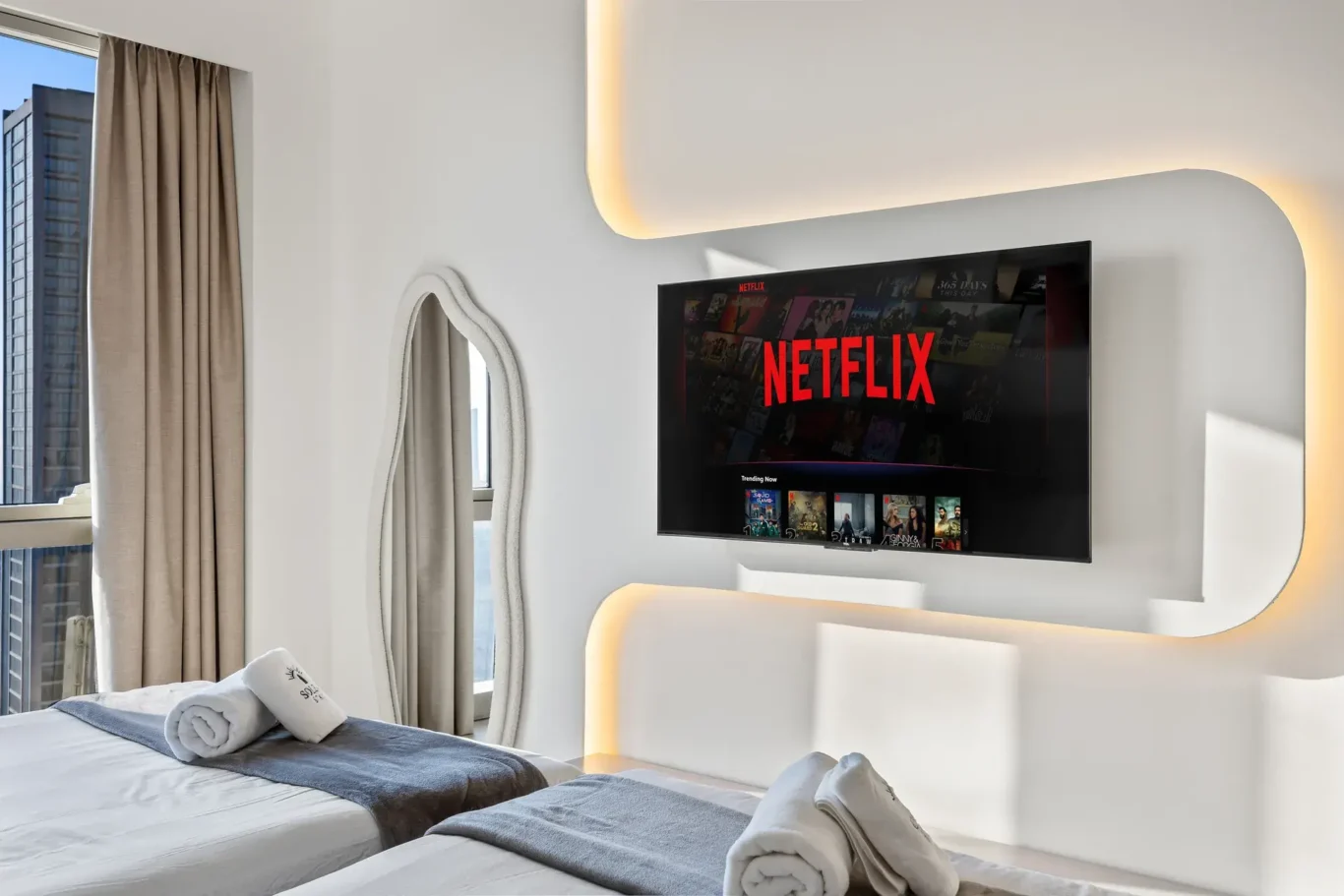 Bedroom TV wall with soft LED lighting and an organic mirror. Airbnb photography by MRPS for Solea Stay in Dubai.