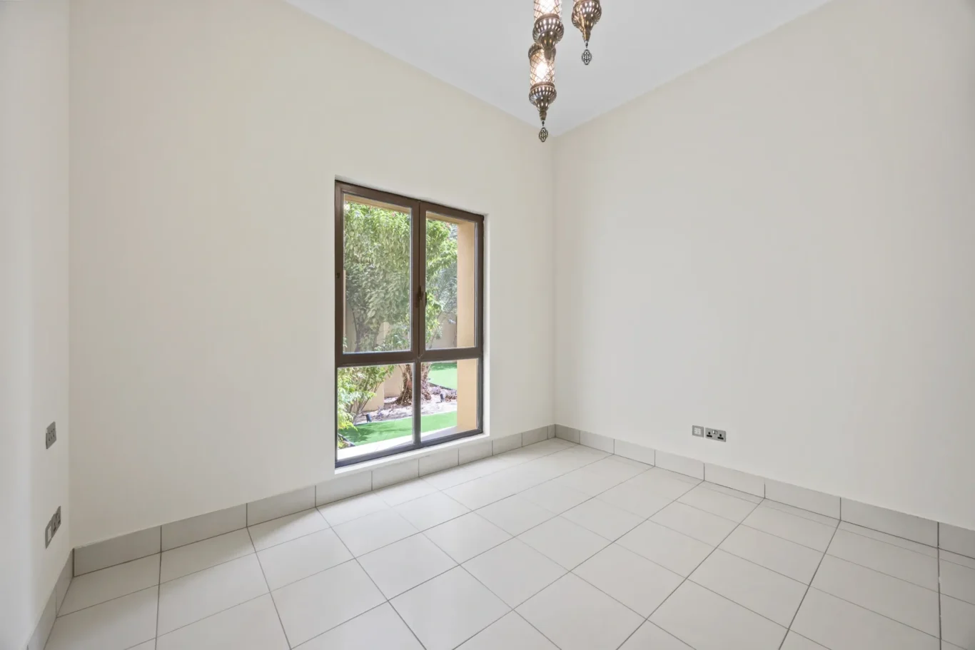 Second bedroom window with greenery view in an unfurnished two-bedroom garden apartment in Old Town, Downtown Dubai, photographed for ELITE Property Brokerage.