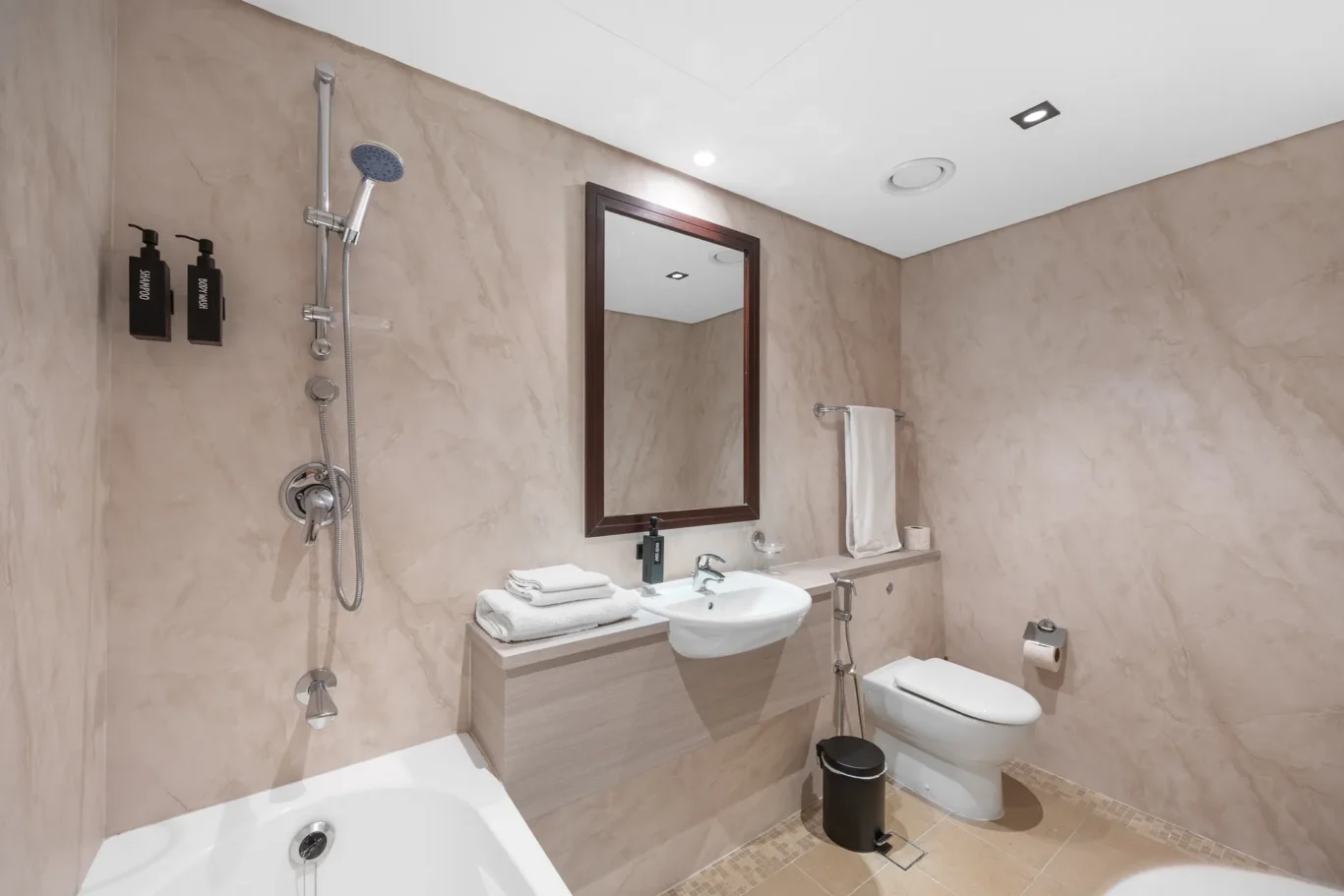 Bathroom with toilet and bathtub in a Your Stay Apartments one-bedroom at Sky Gardens, DIFC, Dubai.