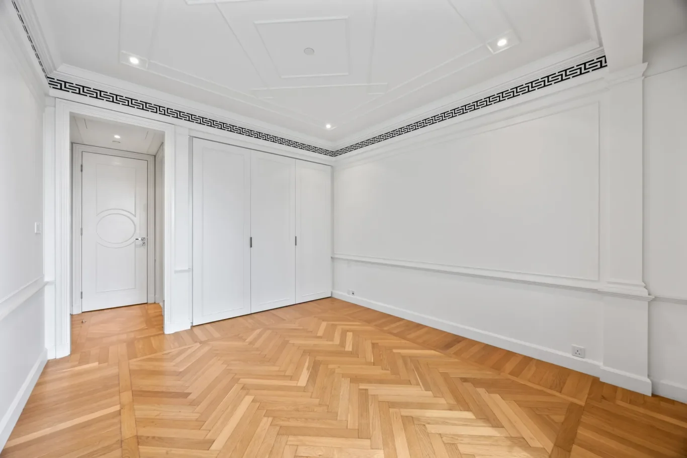 Bedroom with built-in wardrobes and parquet floor in a three-bedroom residence at Palazzo Versace Dubai, Jaddaf Waterfront, photographed for Concierge Auctions.
