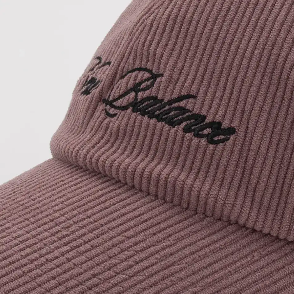 Close-up of the script logo on the mauve corduroy New Balance cap. E-commerce product photography for New Balance by MRPS in Dubai.