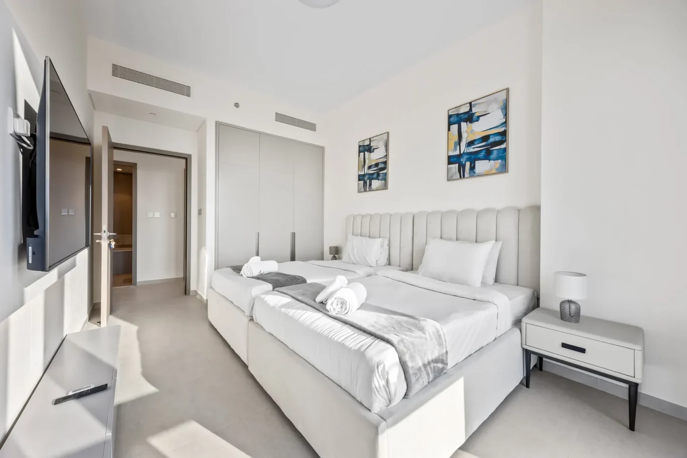 Second bedroom with bed, side tables and blue wall art. Airbnb photography by MRPS for Solea Stay in Dubai.