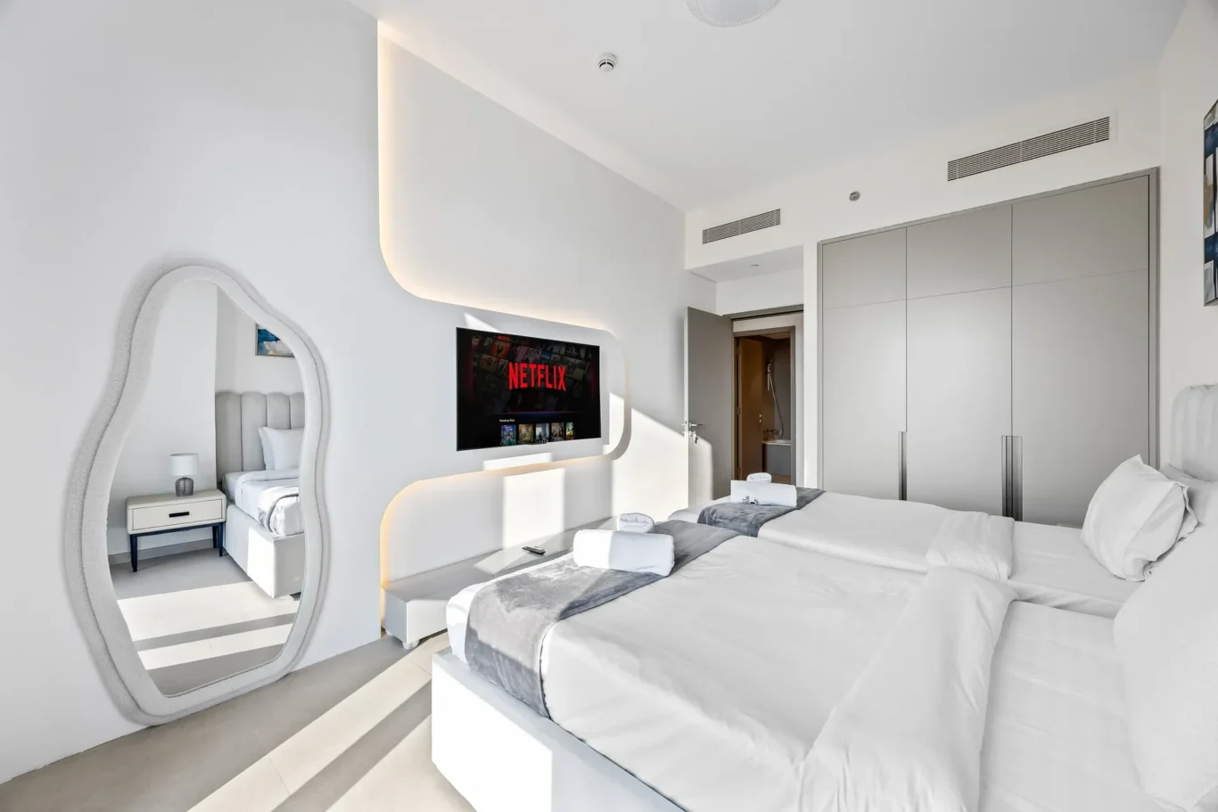 Second bedroom with organic mirror and fitted wardrobe. Airbnb photography by MRPS for Solea Stay in Dubai.