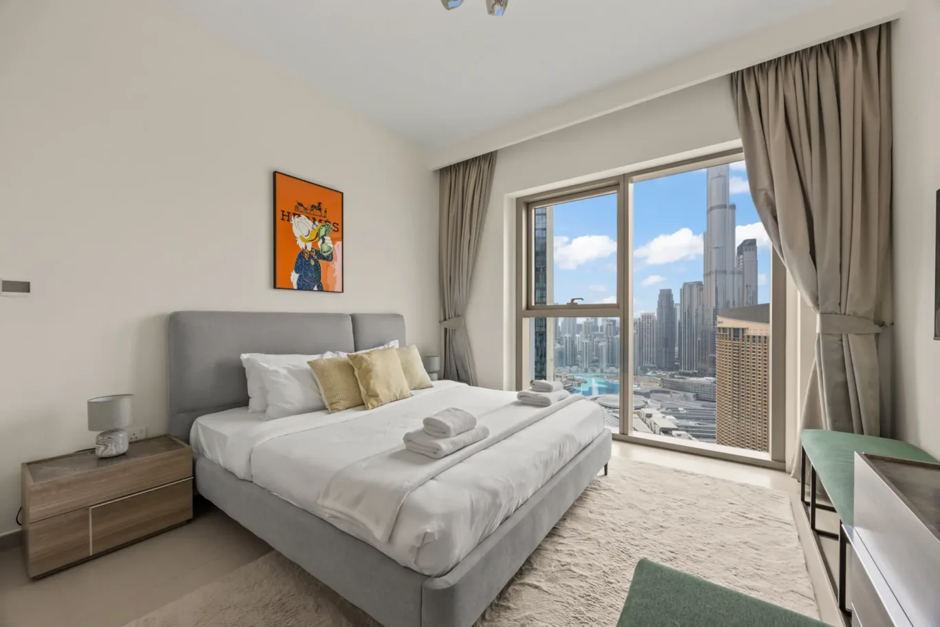 Second bedroom with queen bed, wall art and city view window. Day, twilight and night Airbnb photography by MRPS for Vista Haus Holiday Homes in Downtown Dubai.