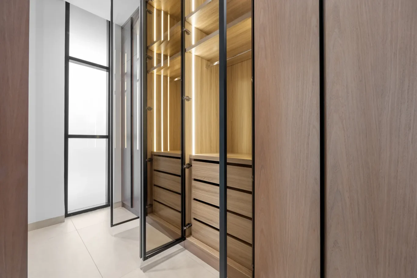 Walk-in wardrobe with lit glass-front cabinets, unfurnished five-bedroom villa in Al Furjan, Dubai.