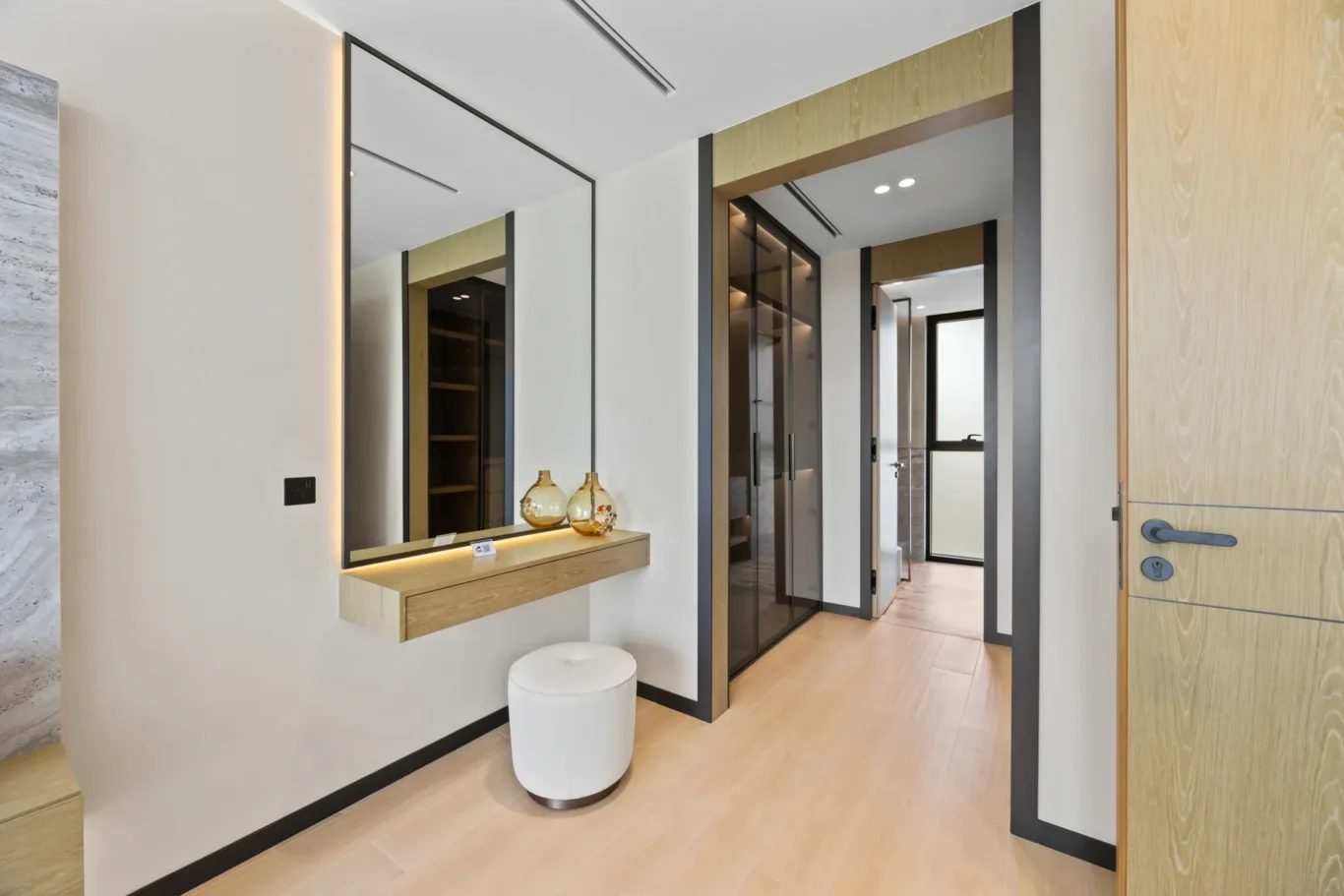 Bedroom dressing table with a mirror and the walk-in wardrobe beyond, luxury villa in Jumeirah Islands, Dubai.