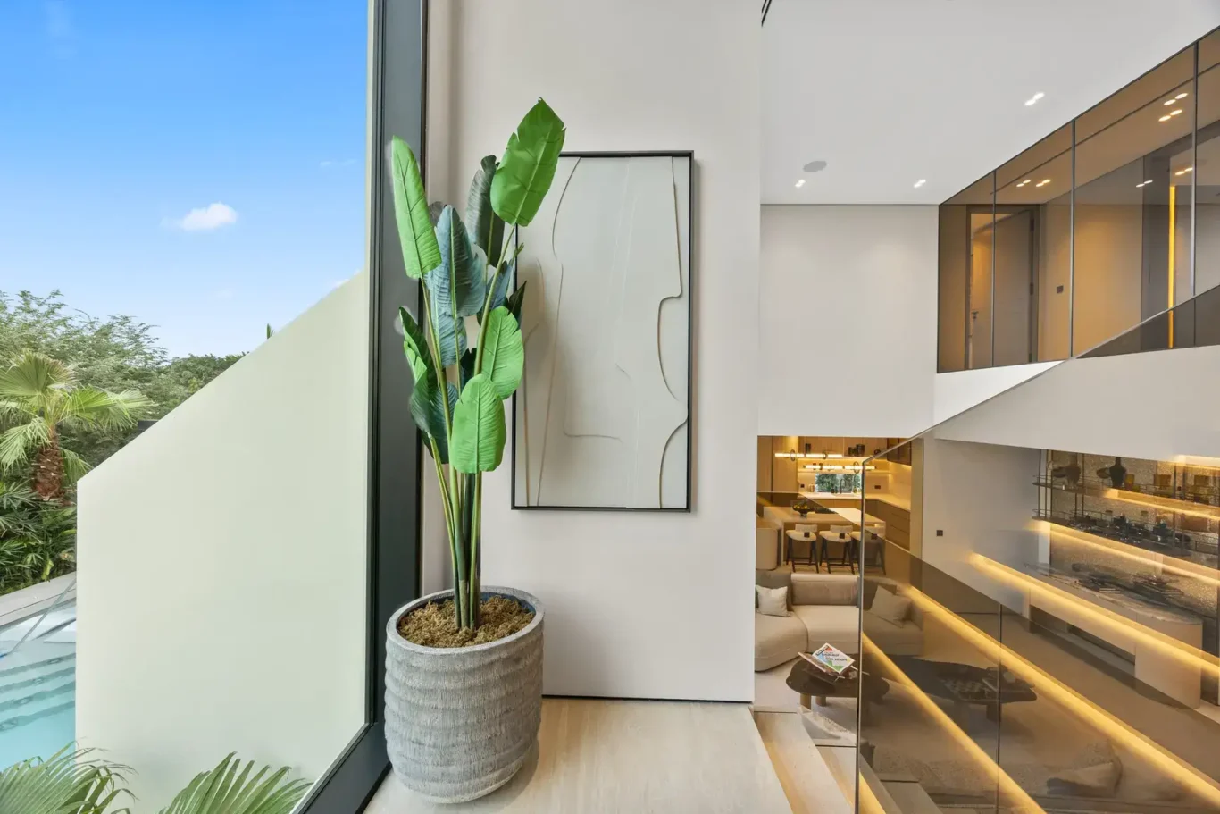 Upper floor window with a plant overlooking the glass roof and pool, luxury villa in Jumeirah Islands, Dubai.