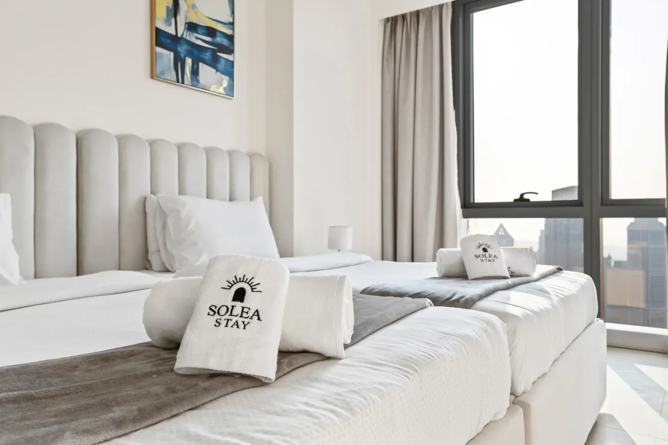 Bed styled with a Solea Stay branded cushion and towels. Airbnb photography by MRPS for Solea Stay in Dubai.