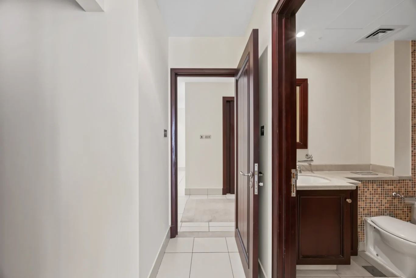 Bedroom with door to the bathroom in an unfurnished two-bedroom garden apartment in Old Town, Downtown Dubai, photographed for ELITE Property Brokerage.