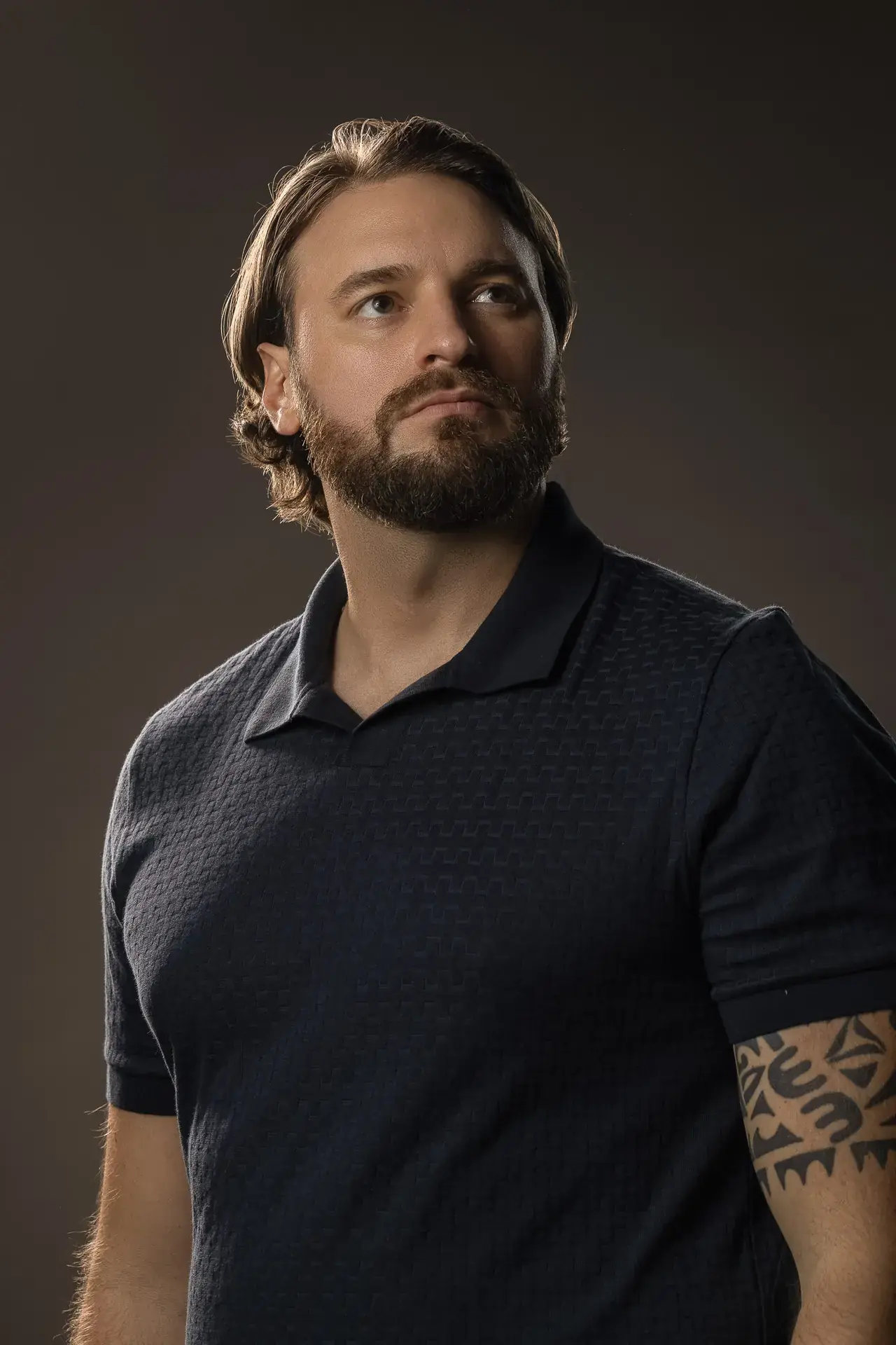 Moody portrait in a dark polo shirt looking up. Lifestyle portrait from an AI digital twin photoshoot at the MRPS studio in Dubai.