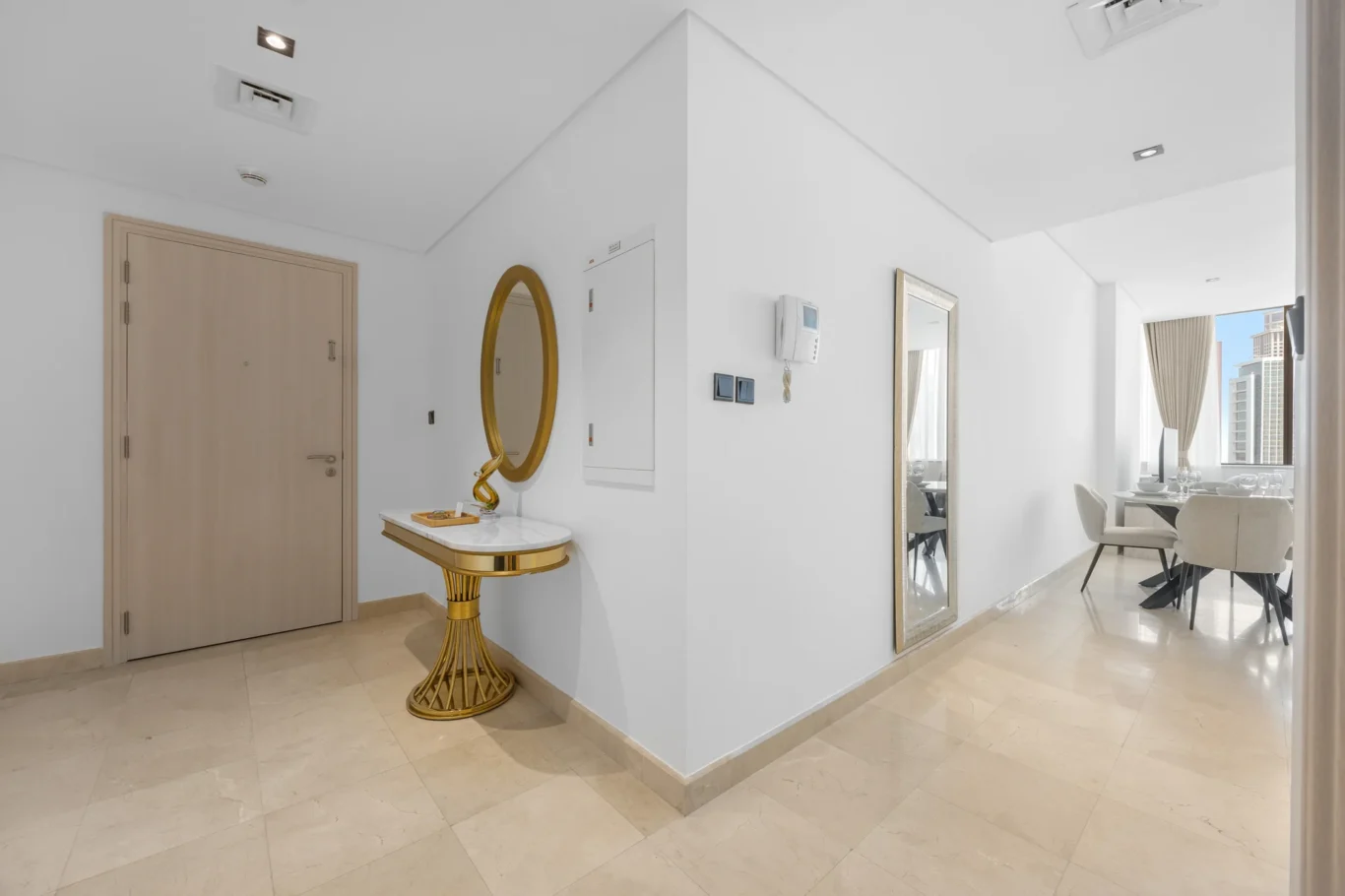 Entrance hall with gold console and mirror in a Your Stay Apartments one-bedroom at Sky Gardens, DIFC, Dubai.