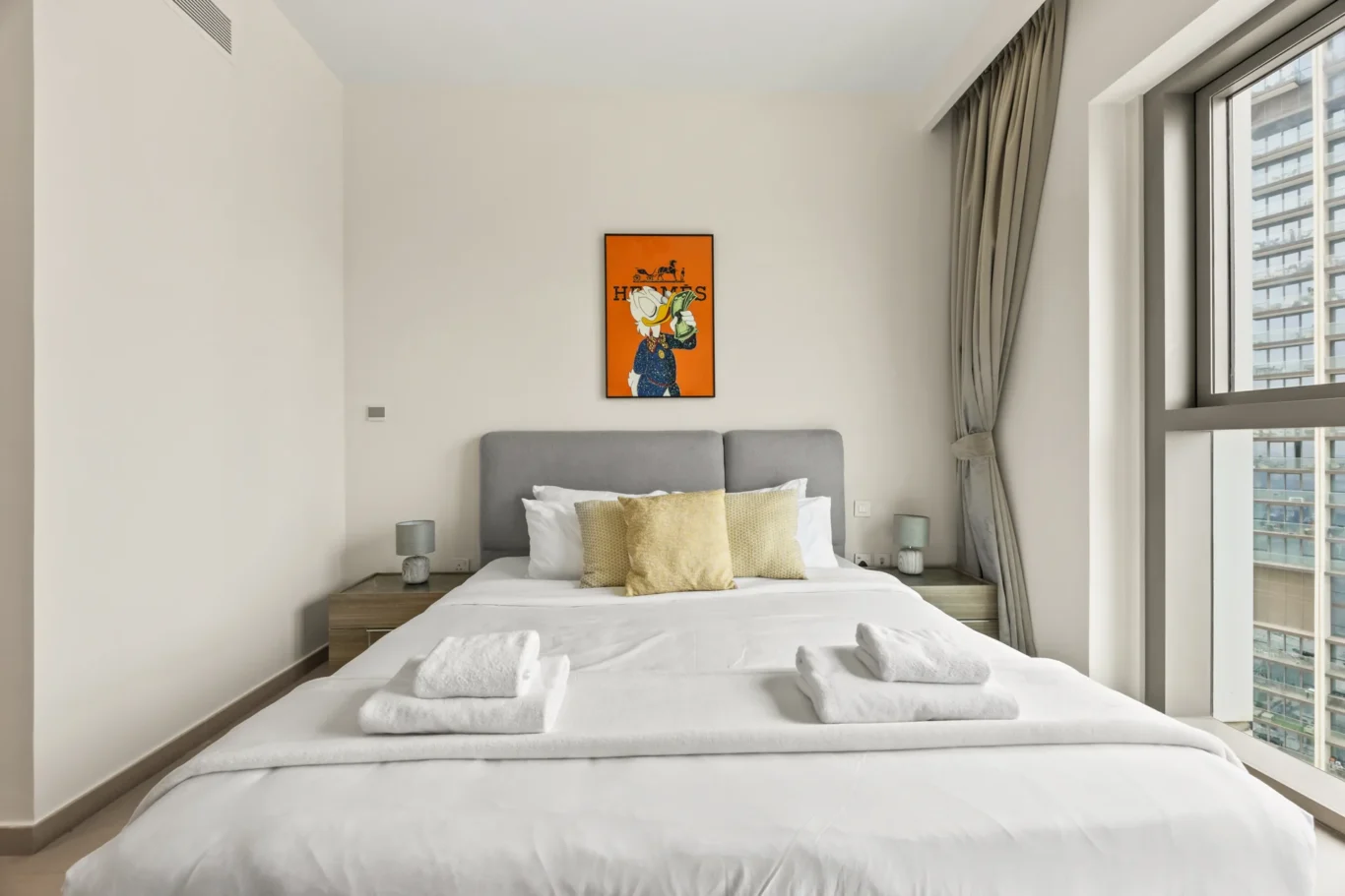 Second bedroom with grey bed, bench and wall art. Day, twilight and night Airbnb photography by MRPS for Vista Haus Holiday Homes in Downtown Dubai.