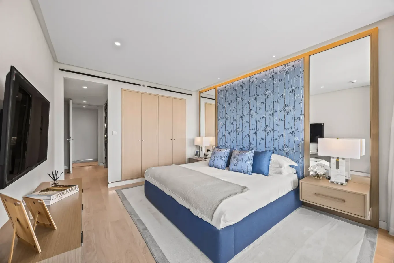 Blue bedroom with built-in wardrobes and TV in a furnished three-bedroom residence at Atlantis The Royal, Palm Jumeirah, photographed for Apex Homes Real Estate.