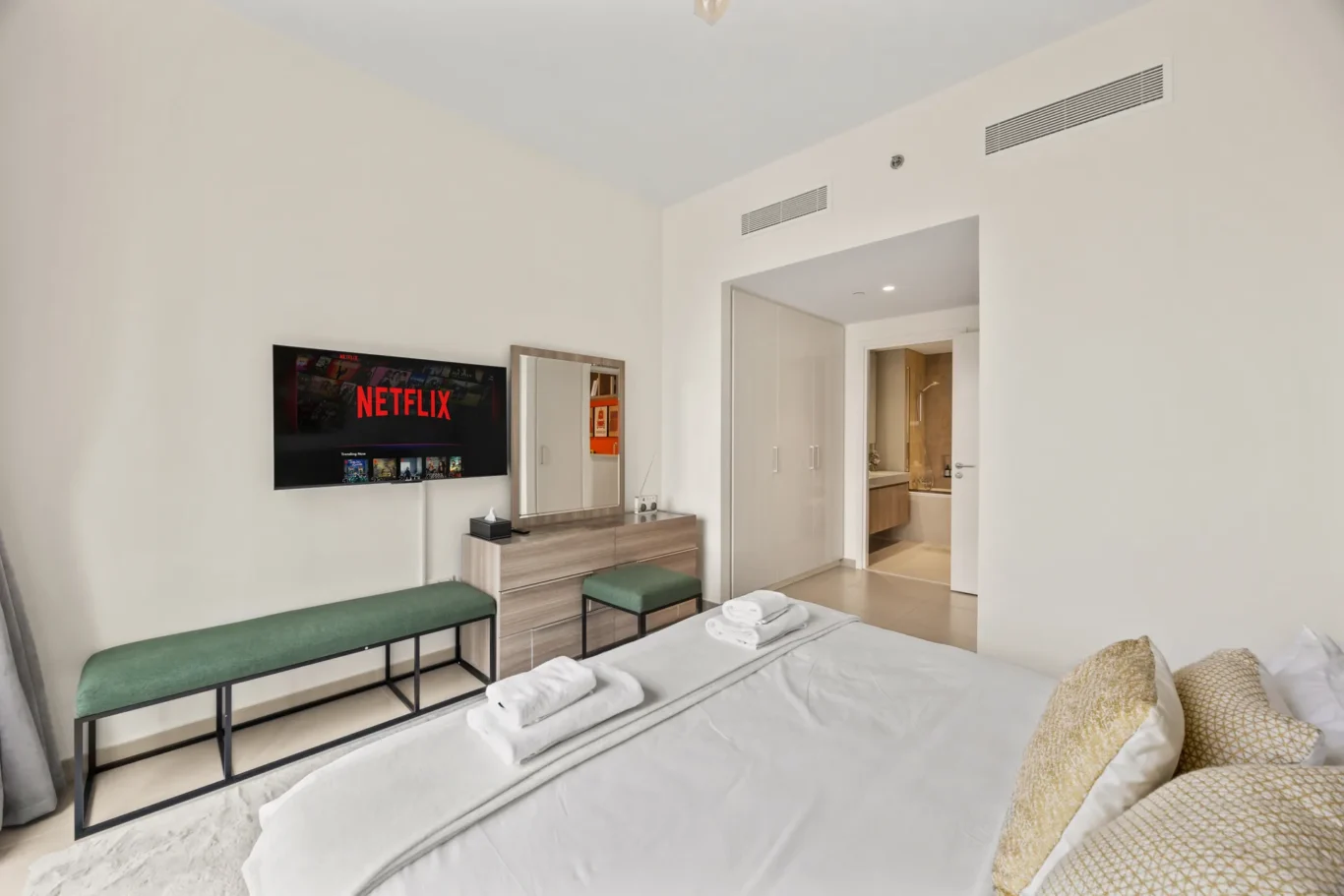 Second bedroom with wall mounted TV and fitted wardrobes. Day, twilight and night Airbnb photography by MRPS for Vista Haus Holiday Homes in Downtown Dubai.