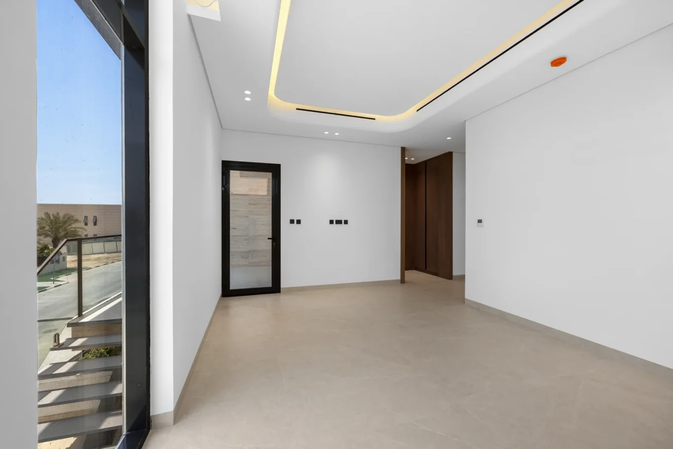 Bedroom with a balcony and floor-to-ceiling window, unfurnished five-bedroom villa in Al Furjan, Dubai.