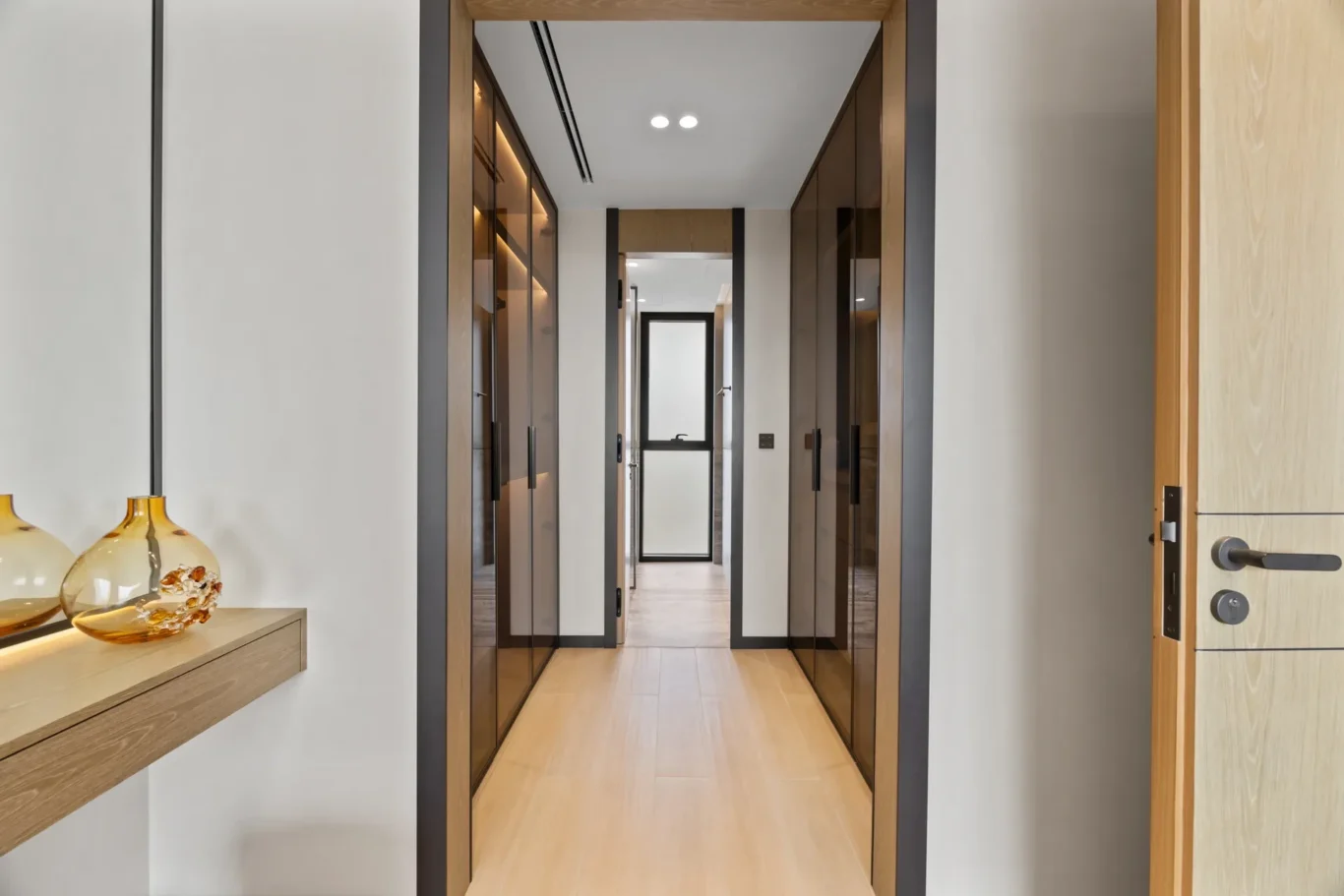 Walk-in wardrobe corridor with glass-front closets, luxury villa in Jumeirah Islands, Dubai.