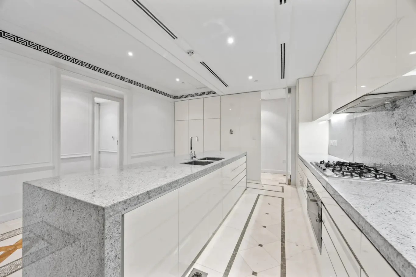 Kitchen with gas hob and marble worktops in a three-bedroom residence at Palazzo Versace Dubai, Jaddaf Waterfront, photographed for Concierge Auctions.