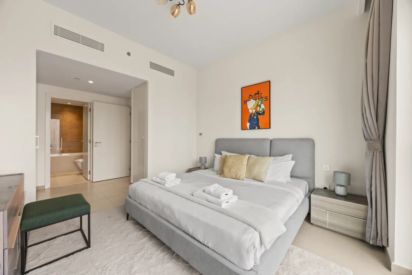 Second bedroom with bed, green bench and window. Day, twilight and night Airbnb photography by MRPS for Vista Haus Holiday Homes in Downtown Dubai.