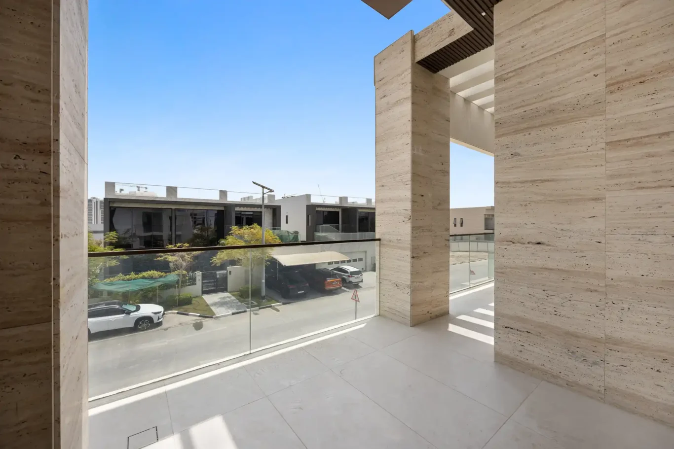Balcony with travertine cladding and a view over the community, unfurnished five-bedroom villa in Al Furjan, Dubai.