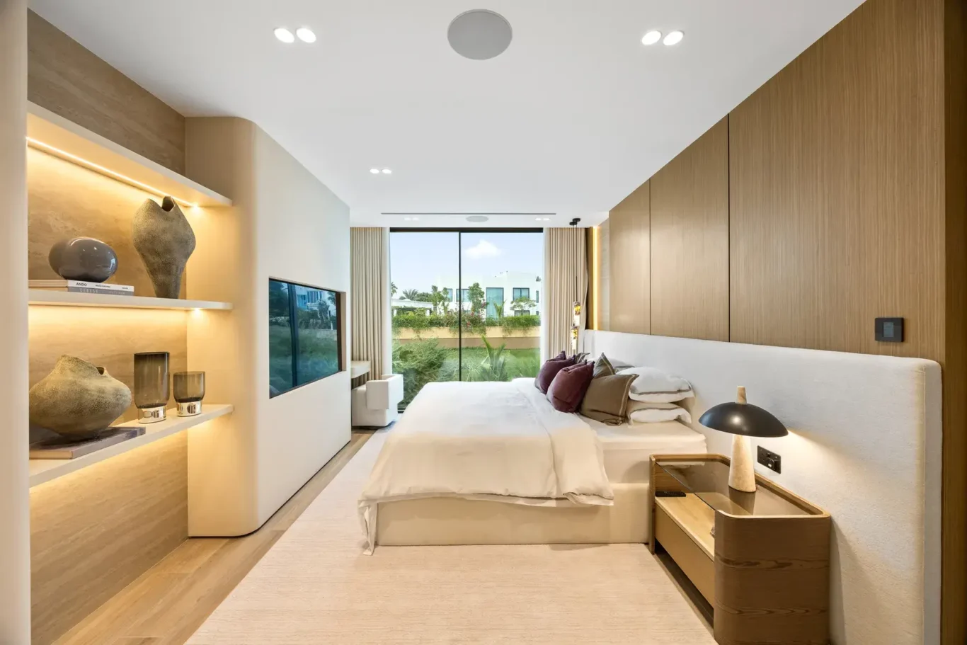 Upstairs bedroom with lit shelves and a garden view, luxury villa in Jumeirah Islands, Dubai.