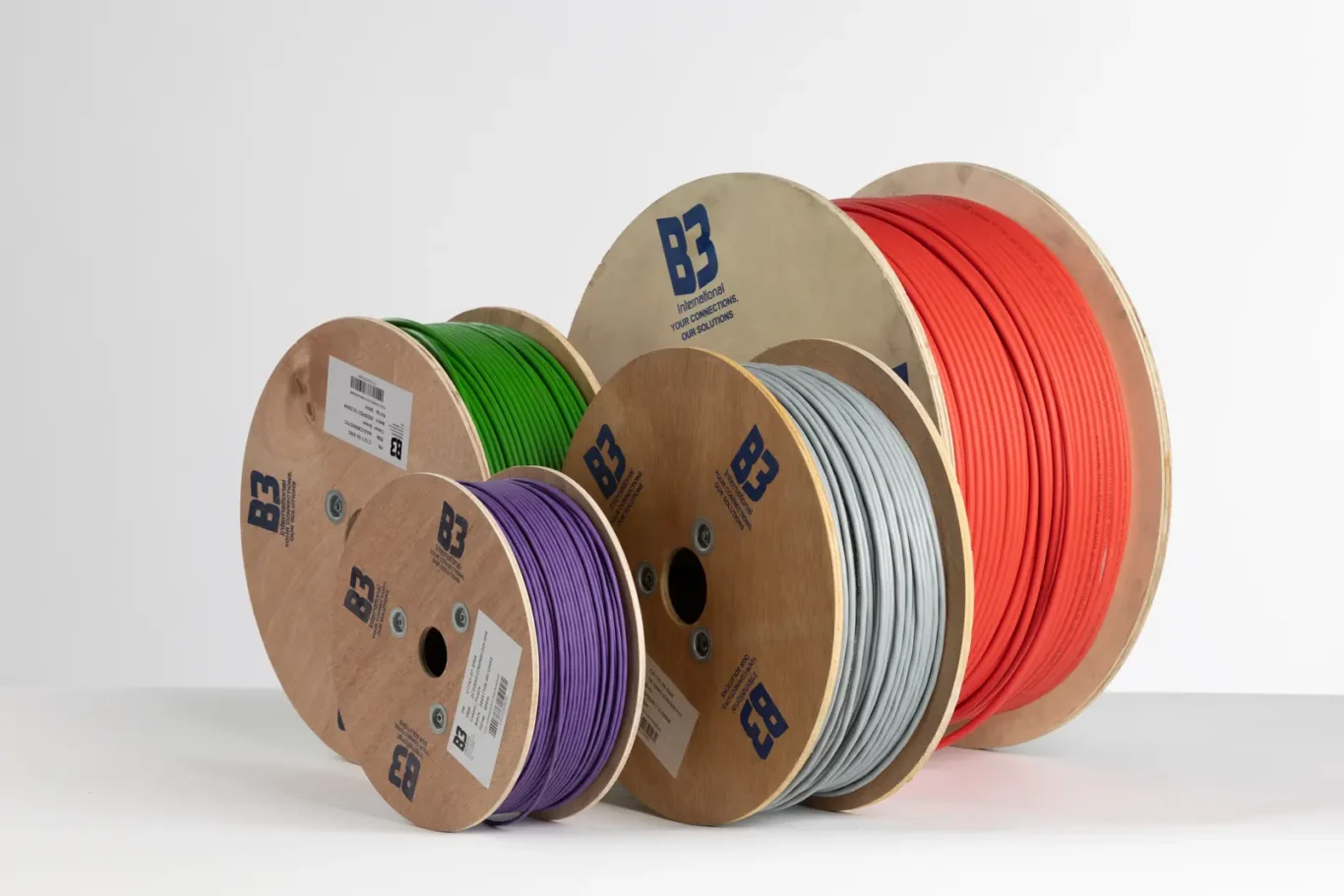 Four B3 International cable drums in green, purple, grey and red photographed together in the MRPS studio in Dubai.