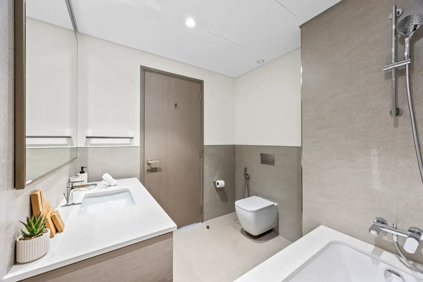 Bathroom with bathtub and wall hung toilet. Airbnb photography by MRPS for Solea Stay in Dubai.