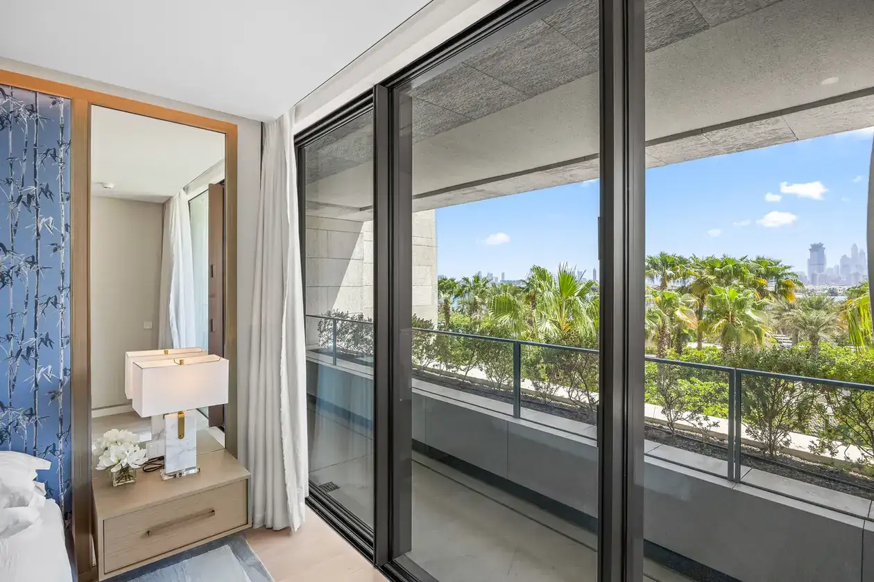 Bedroom view to the balcony and city skyline in a furnished three-bedroom residence at Atlantis The Royal, Palm Jumeirah, photographed for Apex Homes Real Estate.