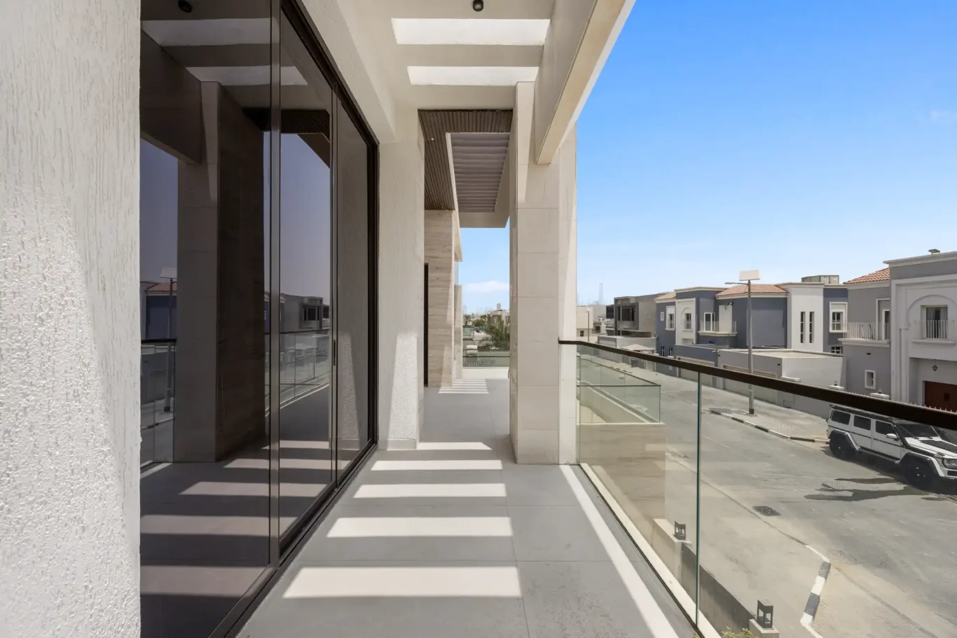 Balcony with a glass balustrade and street view, unfurnished five-bedroom villa in Al Furjan, Dubai.