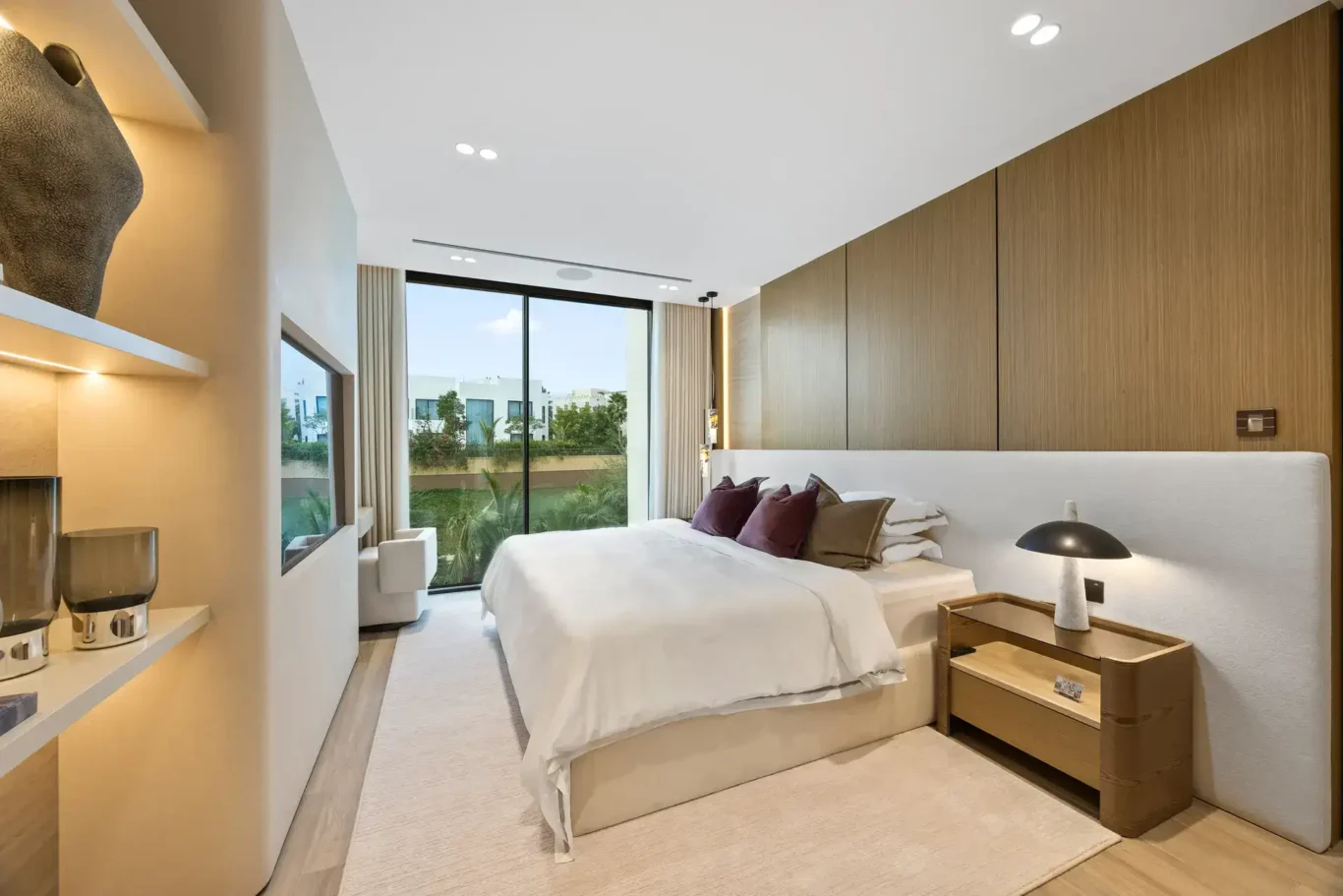 Bedroom with a wide upholstered headboard and wood panelling, luxury villa in Jumeirah Islands, Dubai.