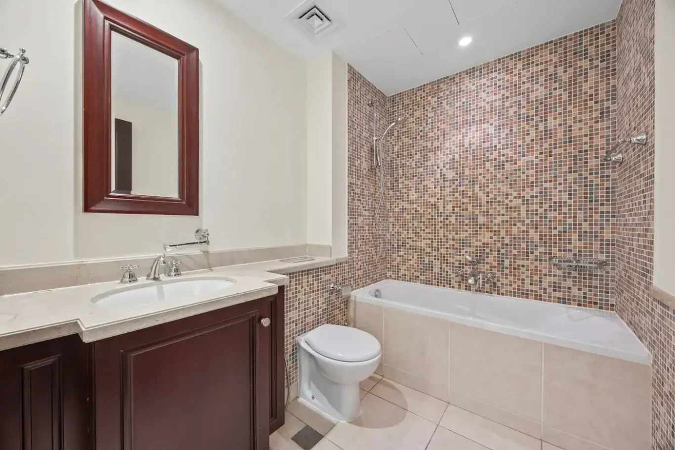 Bathroom with bathtub and mosaic tiles in an unfurnished two-bedroom garden apartment in Old Town, Downtown Dubai, photographed for ELITE Property Brokerage.