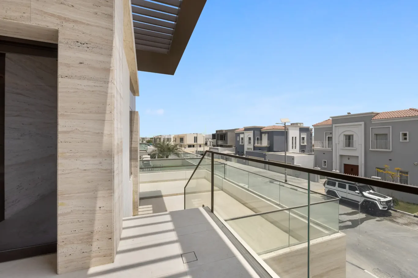 Travertine balcony terrace with a glass balustrade, unfurnished five-bedroom villa in Al Furjan, Dubai.