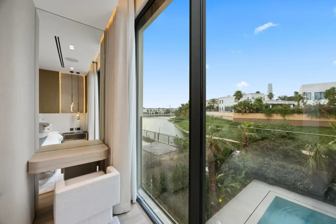 Bedroom window with a view over the garden and pool, luxury villa in Jumeirah Islands, Dubai.