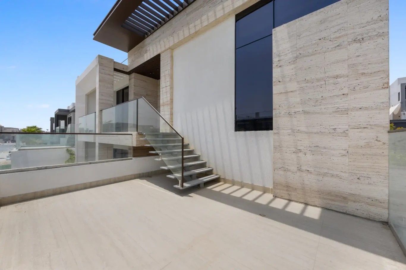 Terrace with stairs to the roof and a glass balustrade, unfurnished five-bedroom villa in Al Furjan, Dubai.