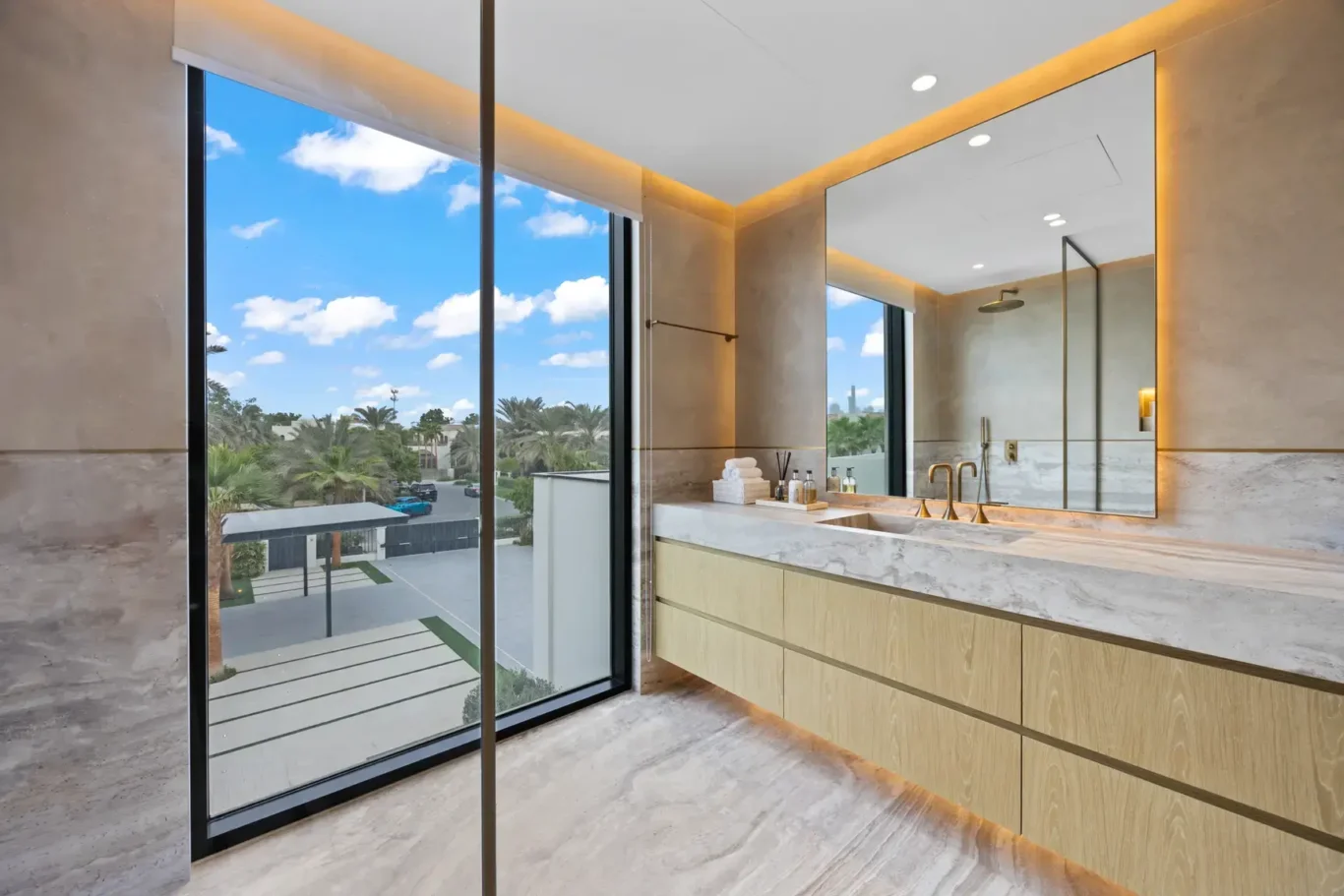Bathroom with a long vanity and a window over the garden, luxury villa in Jumeirah Islands, Dubai.