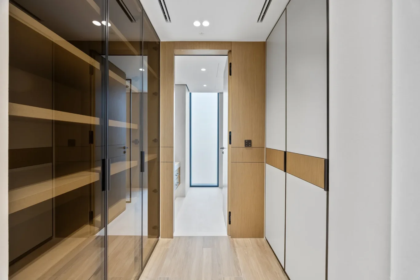 Walk-in wardrobe with glass-front closets, luxury villa in Jumeirah Islands, Dubai.