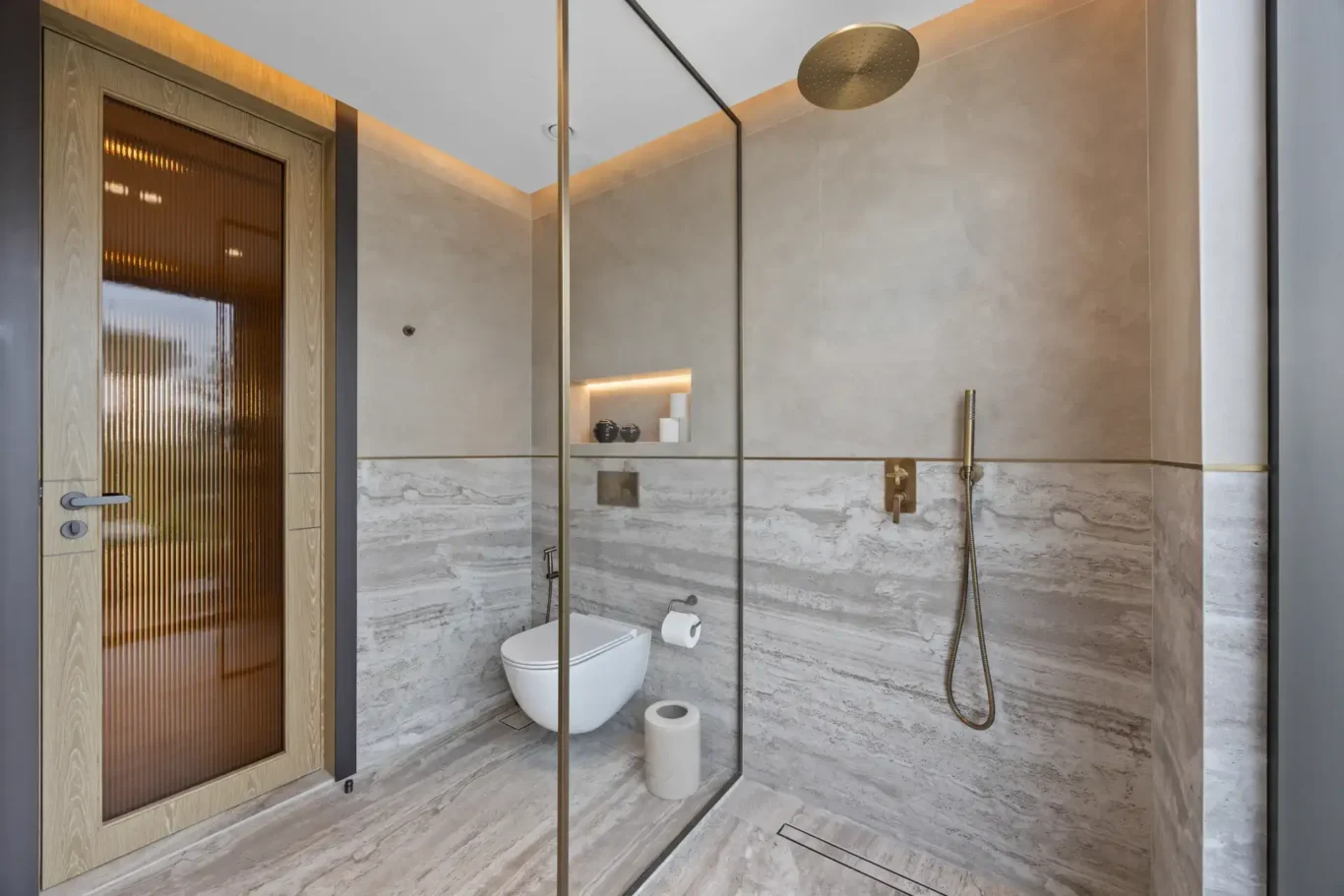 Shower room with a glass partition, rain shower and stone walls, luxury villa in Jumeirah Islands, Dubai.