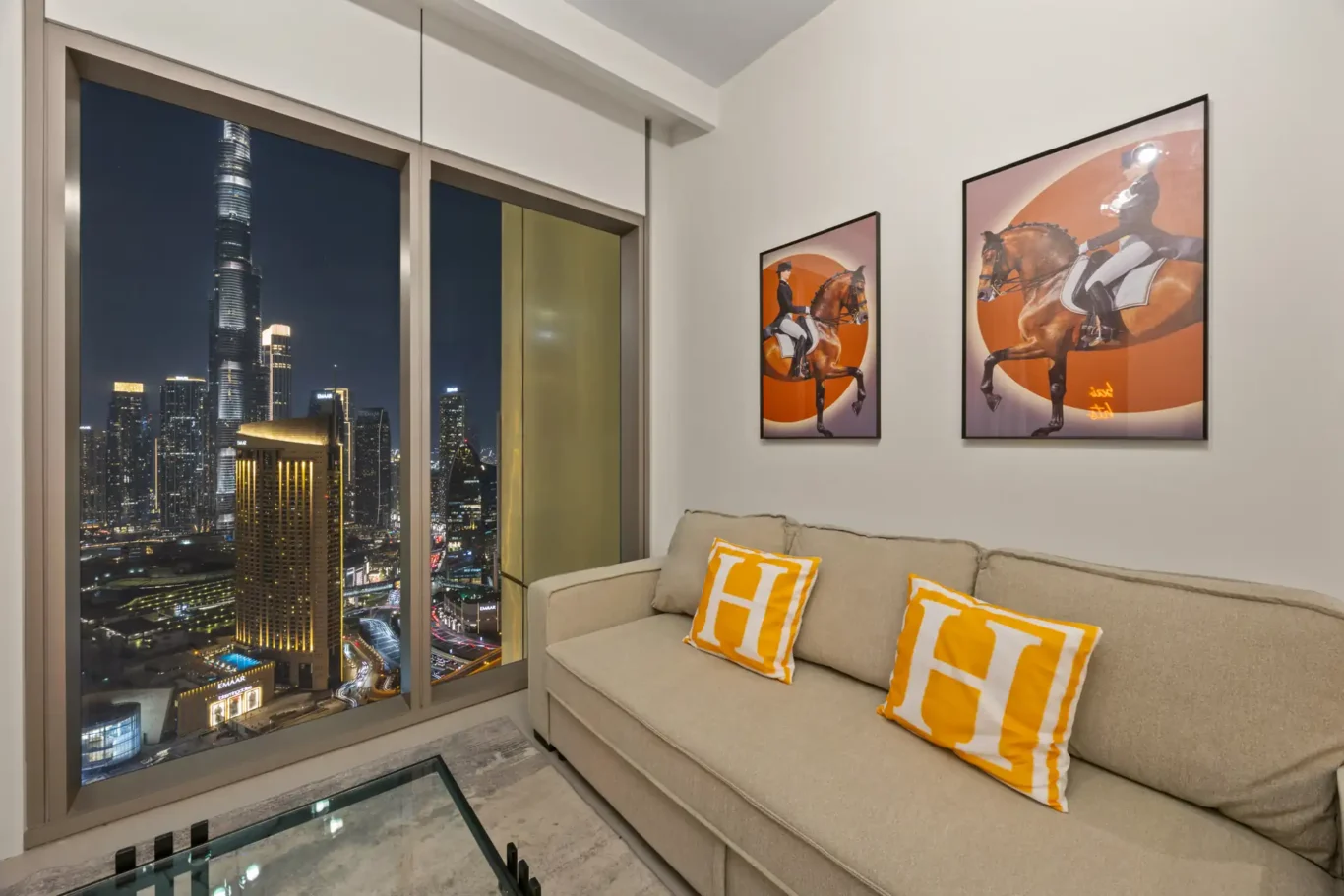 Living room at twilight with the Downtown Dubai skyline in the windows. Day, twilight and night Airbnb photography by MRPS for Vista Haus Holiday Homes in Downtown Dubai.
