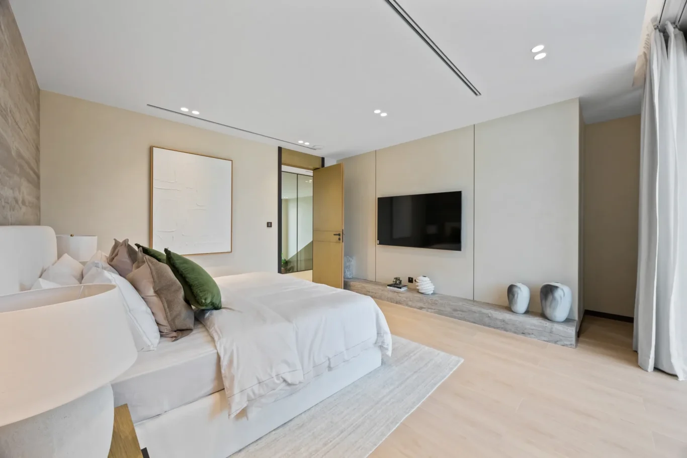 Bedroom with a TV unit, artwork and soft neutral styling, luxury villa in Jumeirah Islands, Dubai.