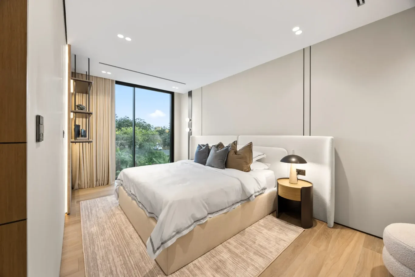 Bedroom seen from the doorway with a garden window, luxury villa in Jumeirah Islands, Dubai.