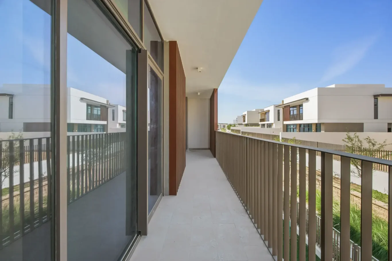 Balcony with glass railing and views over the villas. Villa photography by MRPS in Dubai for ELITE Property Brokerage.